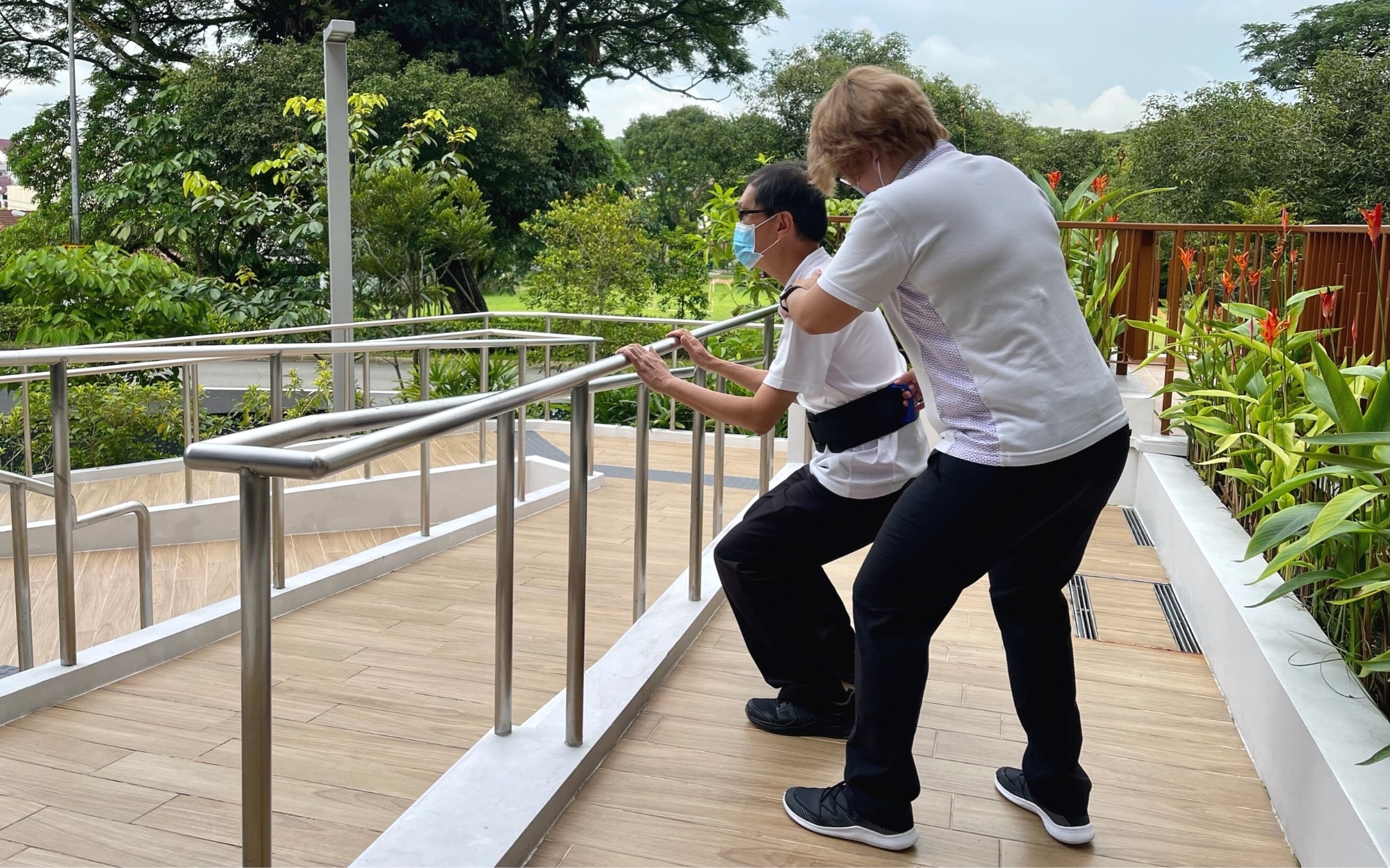 Therapist assisting a senior with neurological rehabilitation exercises to improve mobility and daily function