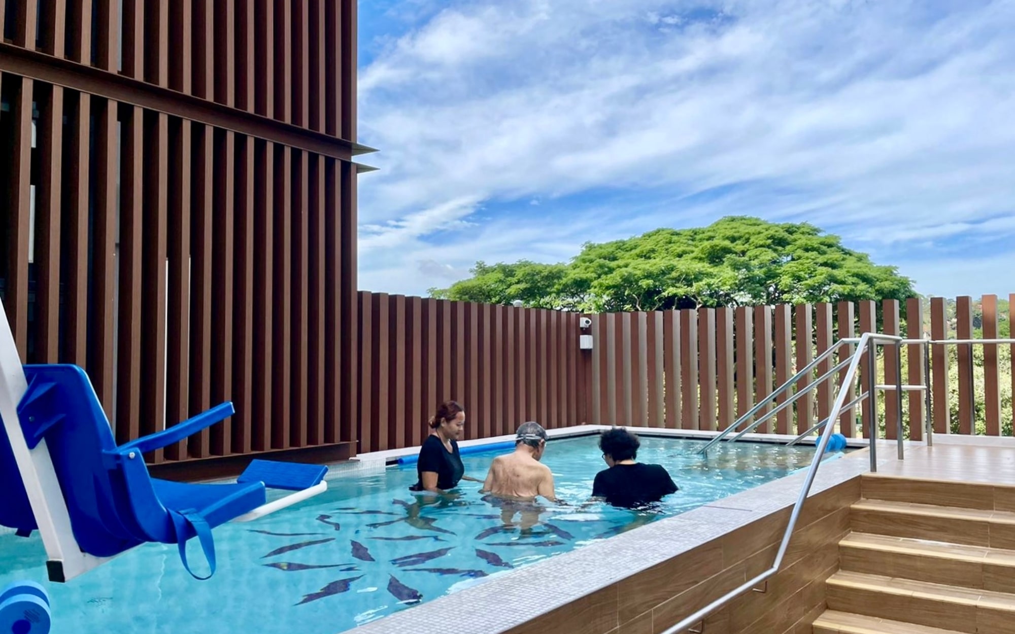 Senior engaging in hydrotherapy with therapist support in a warm, therapeutic pool