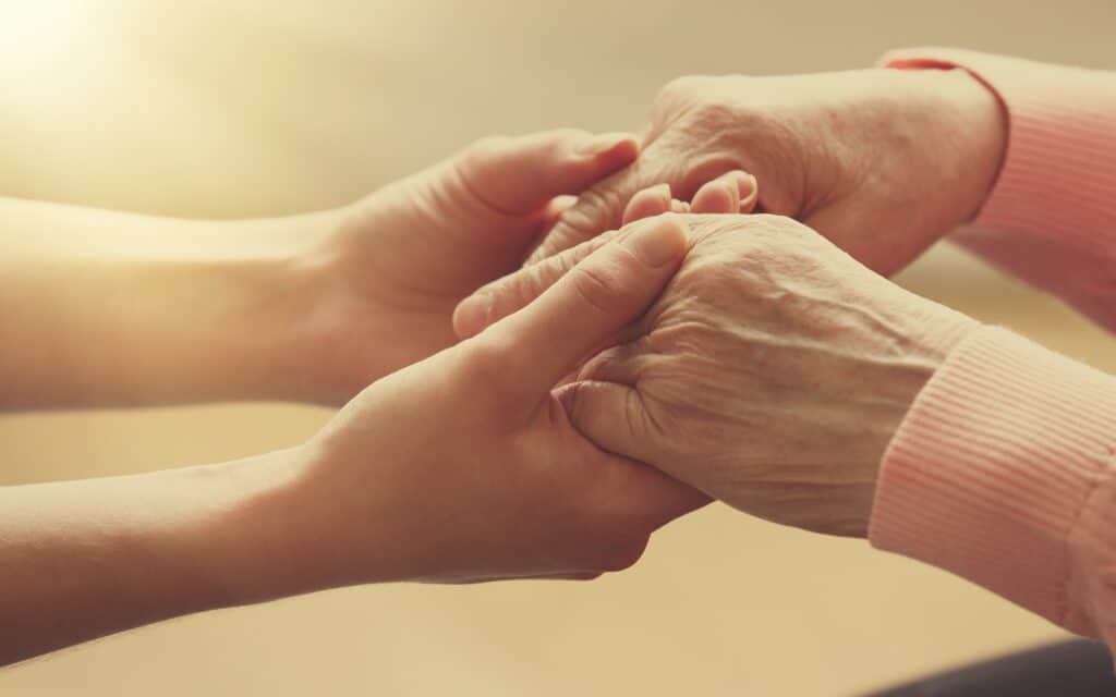 Healthcare worker supporting an elderly patient, symbolizing compassionate palliative care.